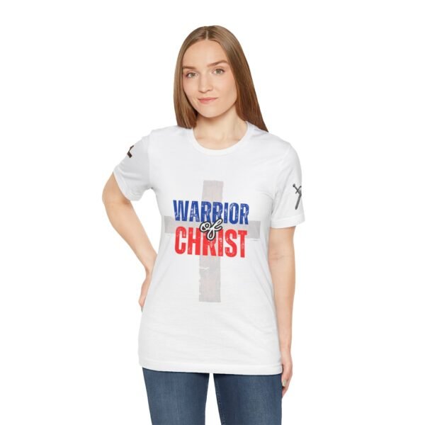 White "Warrior of Christ" women's T-shirt with a distressed cross design and bold red, white, and blue lettering. Christian faith-based apparel.