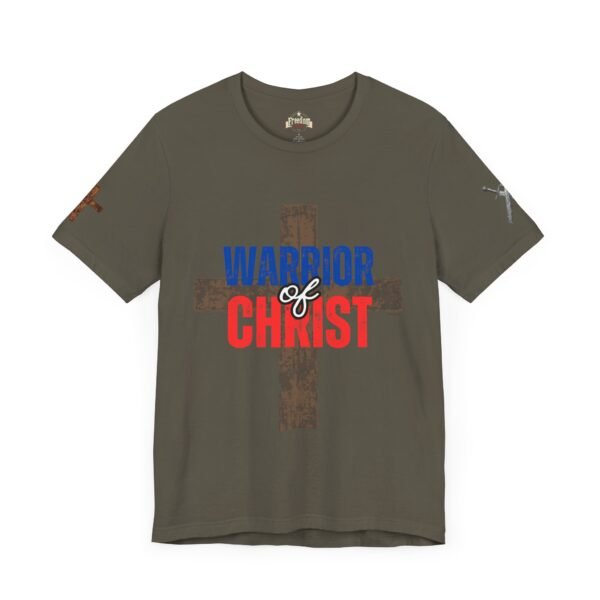 Olive green "Warrior of Christ" T-shirt featuring a bold distressed cross in the background with patriotic red, white, and blue lettering. Christian faith apparel for men and women.