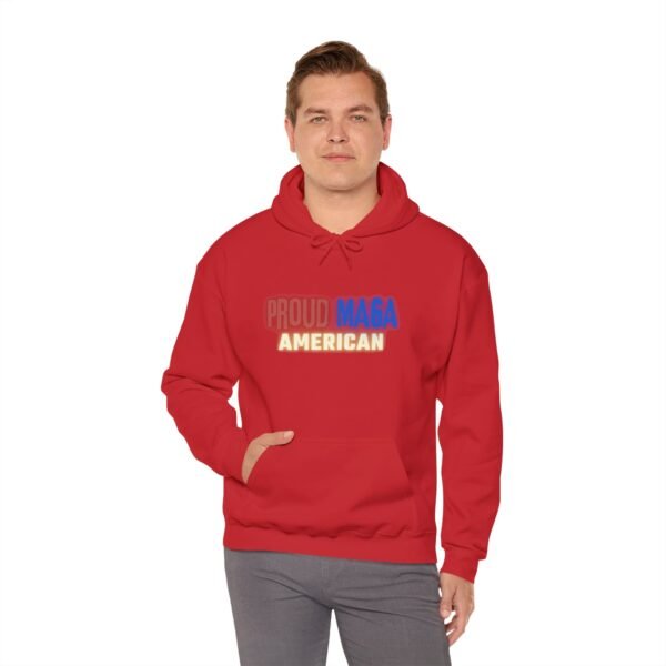 Male model wearing a Proud MAGA American hoodie in bold red. The hoodie features a patriotic design with "Proud MAGA American" text in red, white, and blue. Comfortable fit, perfect for conservative fashion enthusiasts and everyday wear.